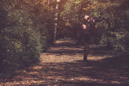 Father throws up his blond son. Happy childhood. Autumn forestの写真素材