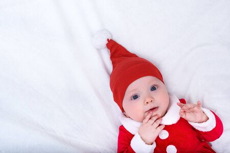 Portrait of cute little girl in a santa hat and costume. Christmas concept. Copy space. White background.の写真素材
