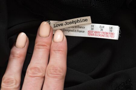 KHARKIV, UKRAINE - September 19, 2019: Tag Love Josephine with female hand on black clothes. Close-upのeditorial素材