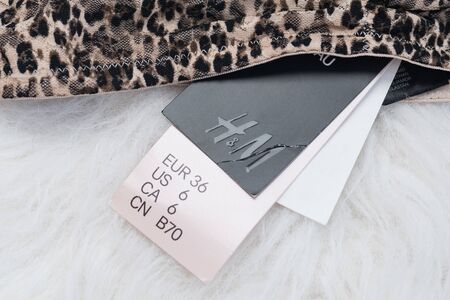 KHARKIV, UKRAINE - September 19, 2019: Label sizes and inscription H&M on the white fur. Thing with...