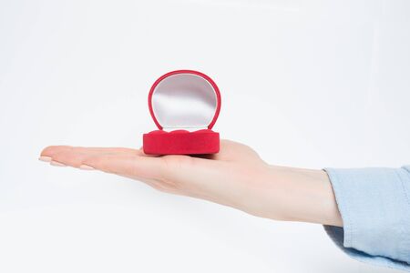 Open empty red jewelry box on female hand. Present. White background