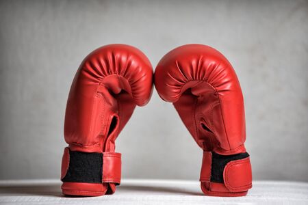 Pair of red boxing gloves on a white background. Close-up