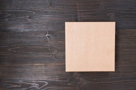 Square craft box on a brown wooden table. Directly above.