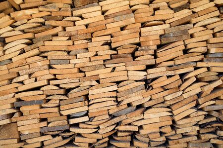 Wall of light brown stack of firewood.