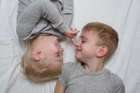 Two boys playing lying on the bed. Brothers. Top view