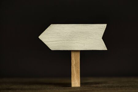 Wooden signpost on black background. Front view, closeup.の写真素材