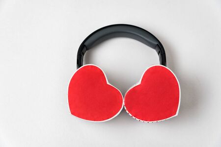 Two boxes in the shape of a heart and headphones on a white background. Listen to your heart