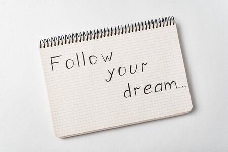 Notepad with the words Follow your dream on white background. Handwritten.
