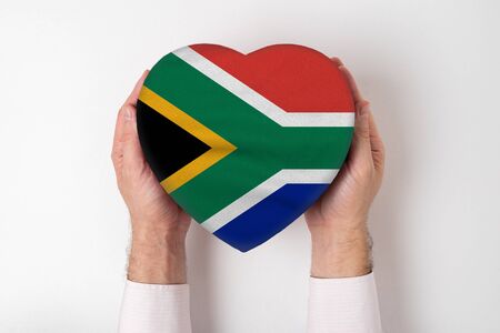 Flag of South Africa on a heart shaped box in a male hands. White backgroundの写真素材