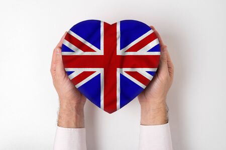 Flag of Great Britain on a heart shaped box in a male hands. White backgroundの写真素材