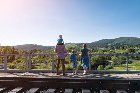 Family stands on the platform on nature background. Waiting for the train. Travel with familyの写真素材