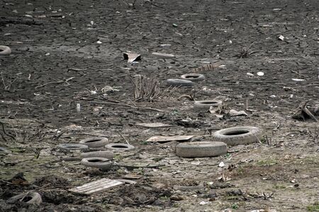 A lot of garbage and old tires on the ground. Dump in town. Environmental protection of nature...