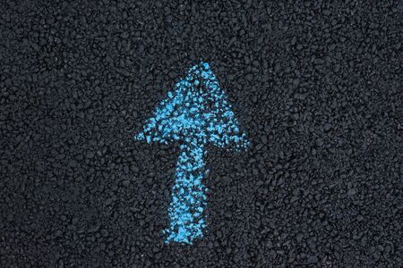 Drawing arrows underfoot. Direction of the path. Figure on the black asphaltの写真素材