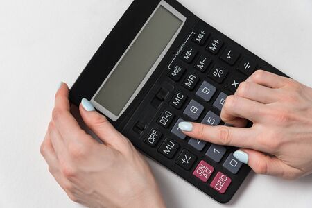 Women hand and calculator on a white background. Budget planning concept.の写真素材