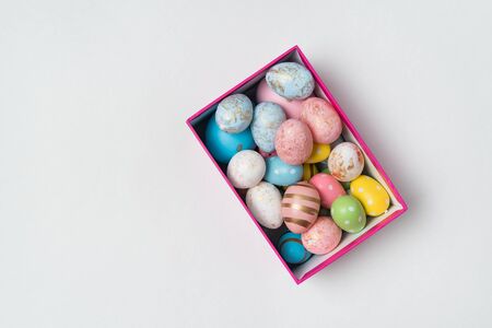 Multi colored easter egg in box. Colorful eggs on white background. Copy space.