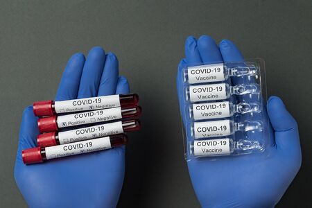 Hands in medical gloves holding blood samples and vaccine coronavirus. infection COVID-19.