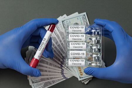 Hands in latex gloves holding vaccine from Covid-19 and test tube with blood. price 2019-nCoV...