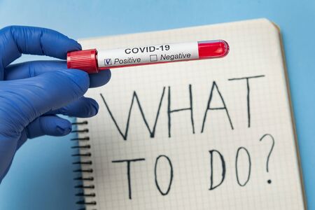 Doctor with tube of biological sample contaminated Covid-19. Sample of blood on background of...