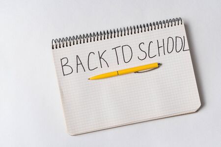 Handwriting notice in notebook BACK TO SCHOOL. White background, top view.の写真素材