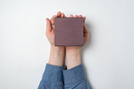 Children's hands holding small gift box on white background. Top viewの写真素材