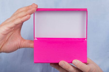 Open pink box in the men's hands. Front view. Close up. Copy space. Moke up.の写真素材