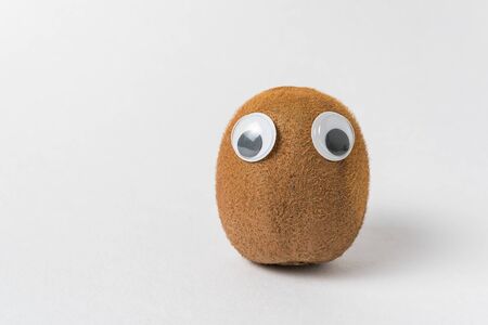 Cute kiwi character with Googly eyes on white background. Vegetarianism concept.の写真素材