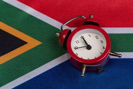National flag of Republic of South Africa and vintage alarm clock, close upの写真素材