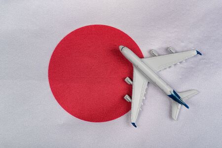 Japan flag and toy airplane close up. Concept of air travel to Japan. Travel to Japan after quarantineの写真素材