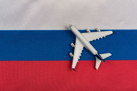 Russian Federation flag and toy airplane close up. Resumption of flights after quarantine, opening...