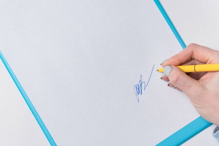 Woman's hand puts his signature on sheet of paper. Sign in document. Close up, copy space, backdrop...