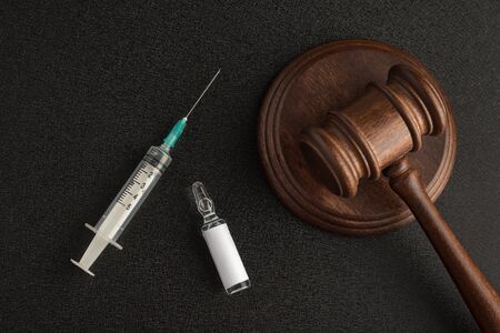 Syringe vial with an empty label and judges gavel or mallet law and. Laws and decisions against medicine.の写真素材
