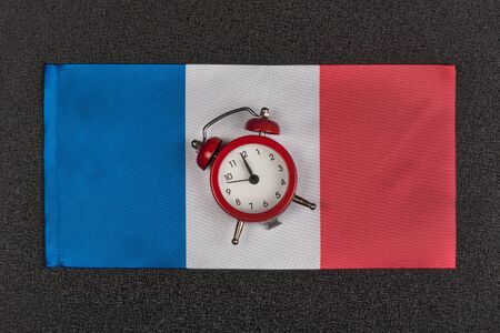Flag of France and vintage alarm clock, close up. Time to learn French.の写真素材