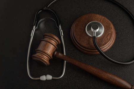 Gavel hammer of judge and stethoscope on black background. Law in medicine. Sentence on medical negligenceの写真素材