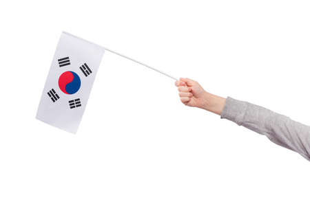 Childrens hand holds flag of South Korea isolated on white background