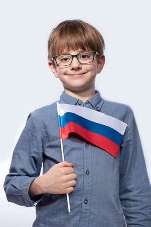 Portrait of teenage boy with flag of Russia in hands isolated on white background. Vertical frame.の写真素材