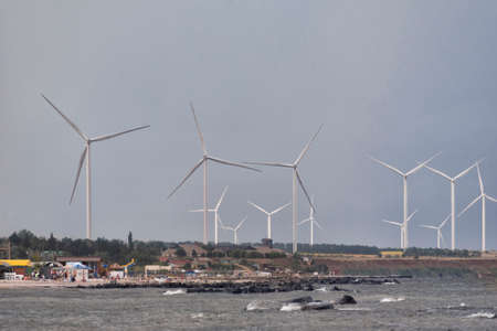 Wind turbines on the background of sea and blue sky. Wind energy. Alternative energy.の写真素材