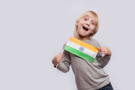Happy boy holding flag of India and makes funny faces. Learning hindi.