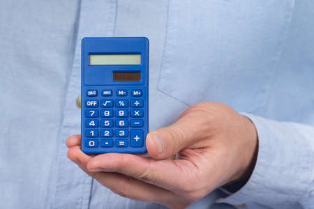 Calculator the hand of man. Close up. Precise calculations. tax calculation investment.の写真素材