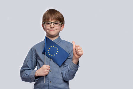Education in Europe. Training in Europe. Boy student holding a EU flag and shows gesture well done.