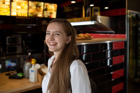 Girl laughs cheerfully on cafe background. Immediacy. Cheerful woman.の写真素材