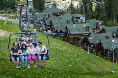 BUKOVEL, UKRAINE - MAY 27, 2018: People using the chairlift at mountain ski resort. People lift to the mountain with ski lift.のeditorial素材