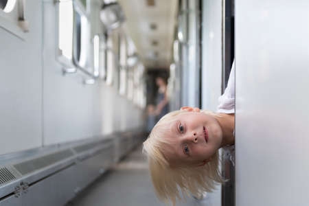 Blond boy in train. Go on vacation and travel by rail. Train travel with children