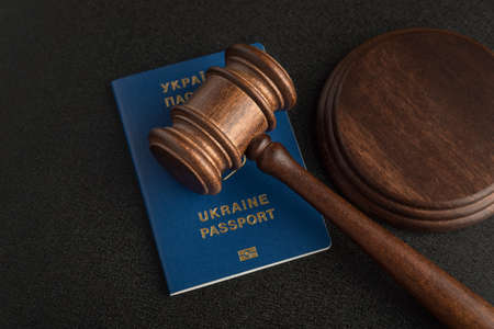Judge gavel and ukrainian passport on black background. Passport Of Ukraine. Obtain citizenship.