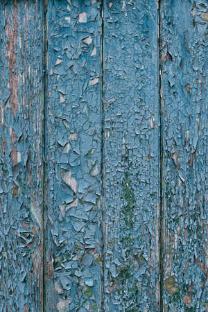 Old blue wooden fence with peeling paint. Abstract textured background. Vertical frame.の写真素材
