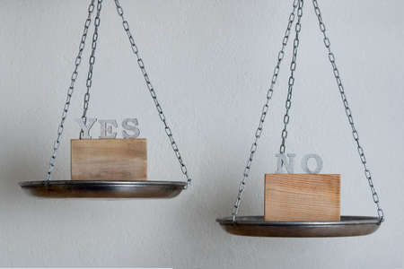Mechanical weight scale with words Yes or No. Choice and decision concept.