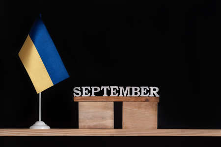 Wooden calendar of September with Ukrainian flag on black background. Dates in Ukraine in Septemberの写真素材