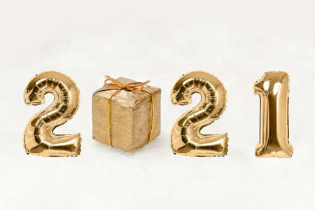 Number 2021 of golden balloons. Gift box. White background. New years concept.の写真素材