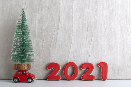 Small Christmas tree stands on toy car next to the 2021 sign. Copy space.の写真素材