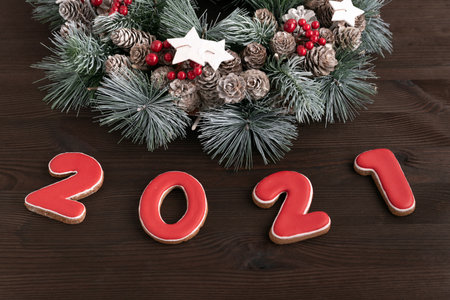 Christmas wreath and Inscription 2021 gingerbread cookie. Wooden background. Close up.の写真素材