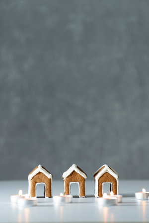 Tasty glazed painted gingerbread houses and candles on gray background. Vertical frame.の写真素材
